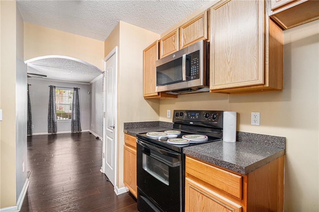 3262 Cascade Parc Boulevard Southwest Atlanta, GA 30311 - Photo 11 of 24 a kitchen with stainless steel appliances granite countertop a stove and a microwave