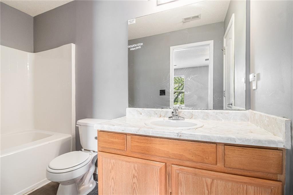 3262 Cascade Parc Boulevard Southwest Atlanta, GA 30311 - Photo 18 of 24 a bathroom with a granite countertop toilet sink and mirror