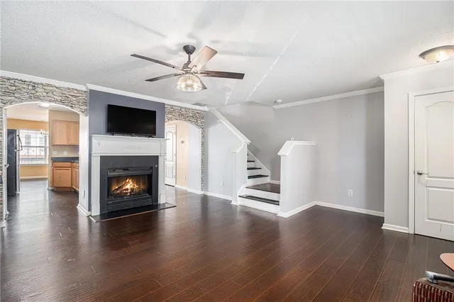 a view of an empty room with wooden floor fireplace and a window