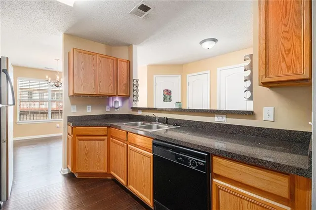 a kitchen with stainless steel appliances granite countertop a sink a stove cabinets and wooden floor