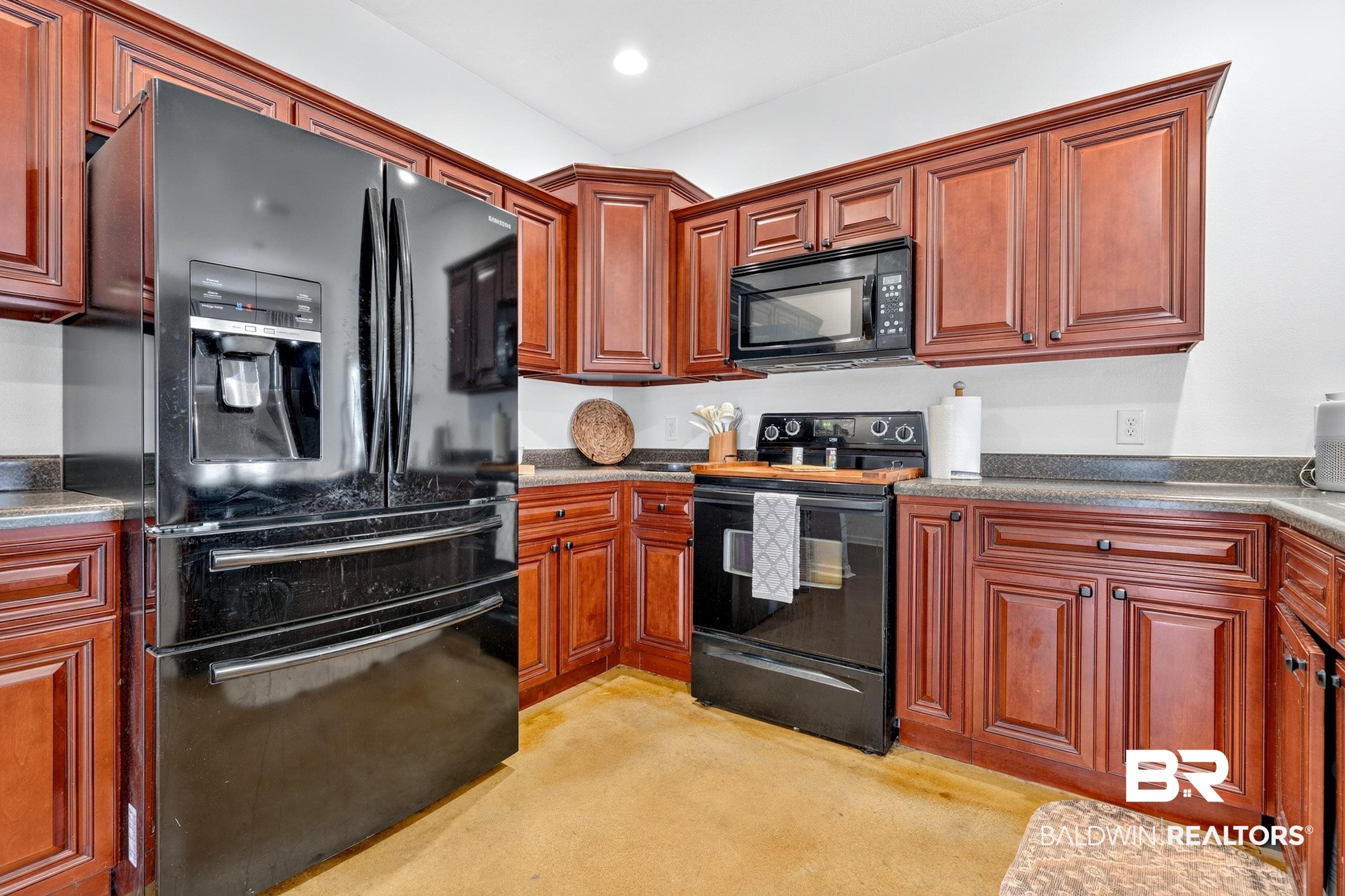 17419 Lewis Smith Drive Foley, AL 36535 - Photo 15 of 38 Corner kitchen featuring dark wood cabinetry, a black French door refrigerator, black range, black built-in microwave, and dark countertops