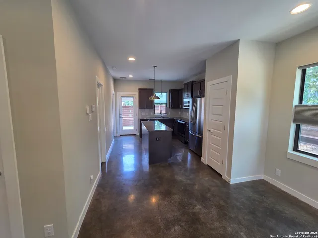 a kitchen with granite countertop a sink cabinets and wooden floor