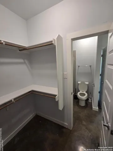 a view of a room with wooden floor and a bathroom