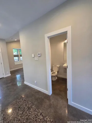 a view of a hallway with a livingroom and a bathroom sink