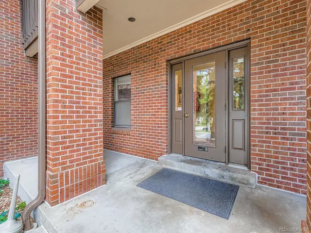 a view of a brick house with floor to ceiling windows