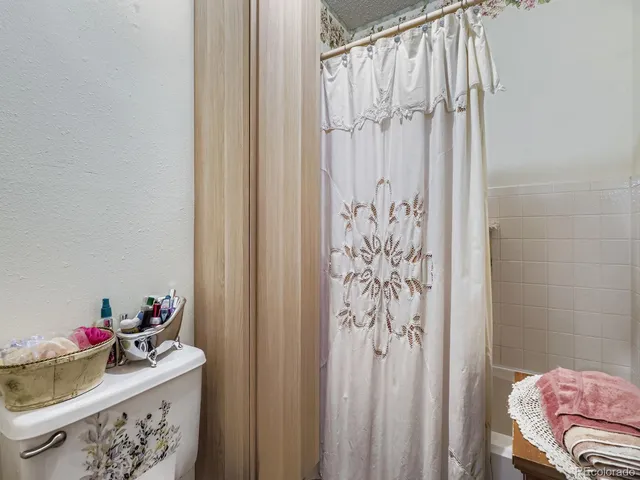 a bathroom with a sink toilet and shower curtain