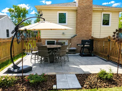 a view of a patio with a table and chairs under an umbrella