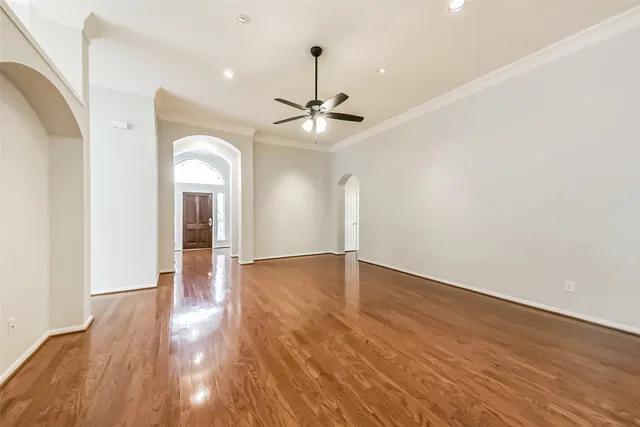 a view of an empty room with a window and wooden floor