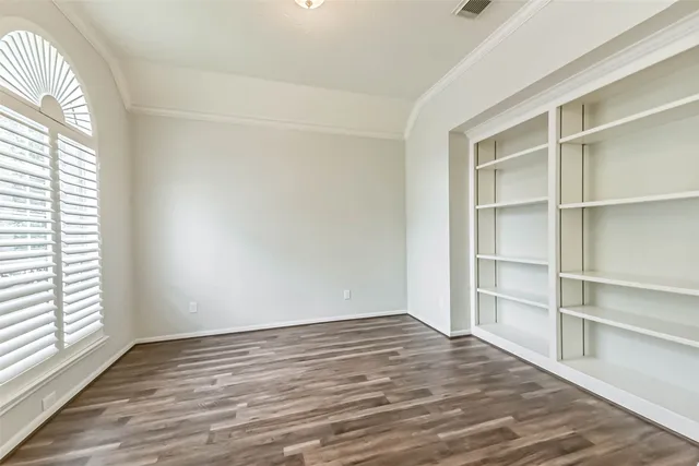 a view of an empty room with wooden floor