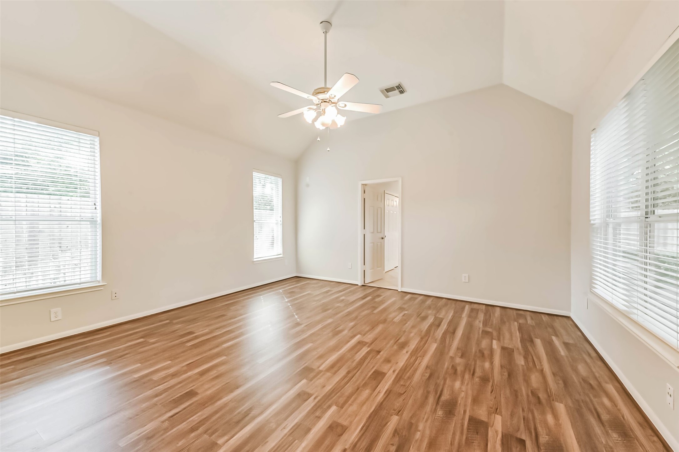 14610 Farrawood Drive Cypress, TX 77429 - Photo 24 of 35 an empty room with wooden floor fan and windows