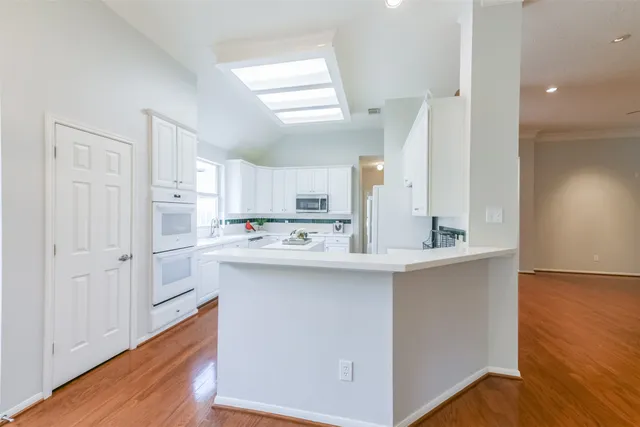 a kitchen with white cabinets sink and white appliances