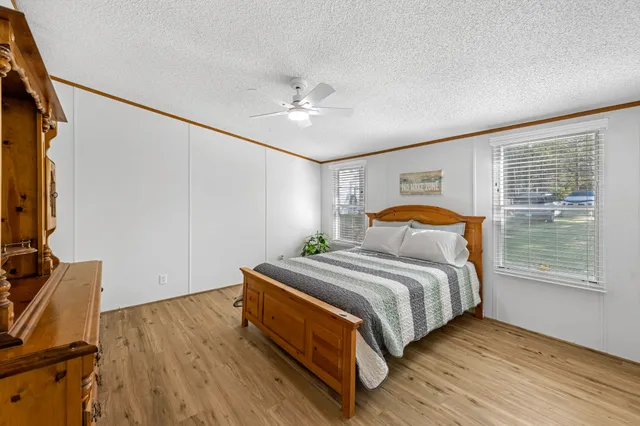 a bedroom with a bed and a flat tv screen on dresser