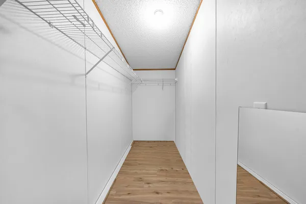 a view of a hallway with wooden floor and entryway