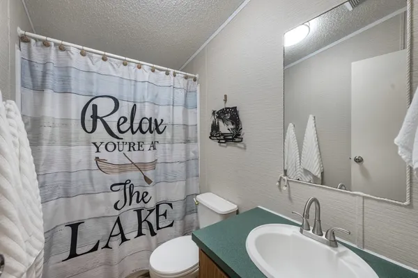 a bathroom with a toilet sink and mirror