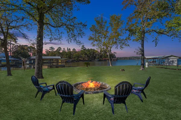 a view of a swimming pool and lounge chairs in back yard of the house