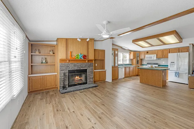 a large kitchen with cabinets wooden floor and stainless steel appliances