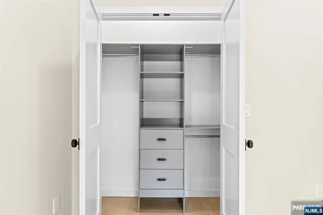 a view of walk in closet with empty racks