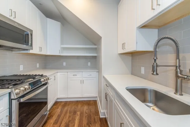 a kitchen with granite countertop a sink stainless steel appliances and cabinets