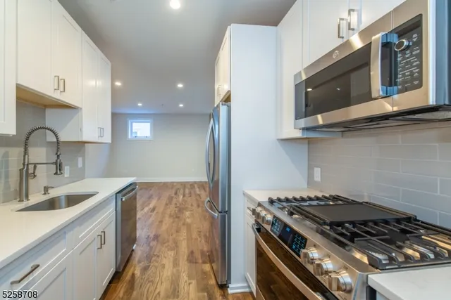 a kitchen with stainless steel appliances granite countertop a sink stove and microwave