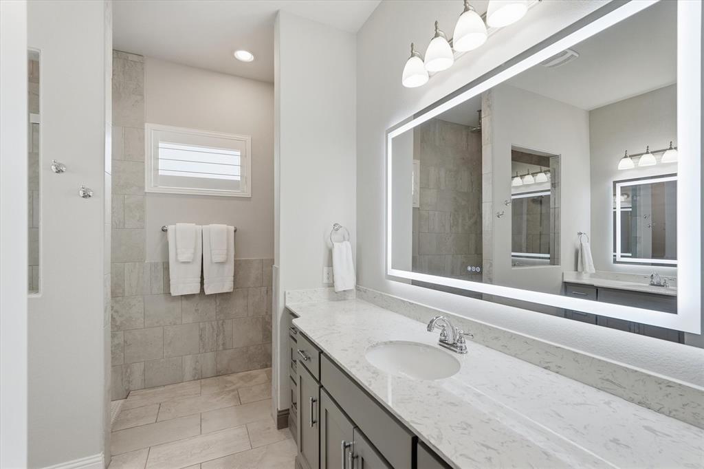8713 Homestead Boulevard Rowlett, TX 75089 - Photo 12 of 28 a bathroom with a granite countertop sink and a mirror