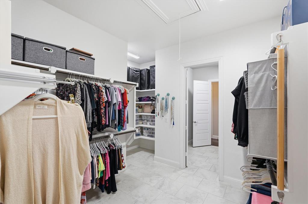 8713 Homestead Boulevard Rowlett, TX 75089 - Photo 14 of 28 a view of walk in closet with clothes and shoes