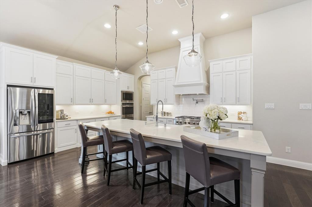 8713 Homestead Boulevard Rowlett, TX 75089 - Photo 4 of 28 a kitchen with kitchen island a dining table and chairs
