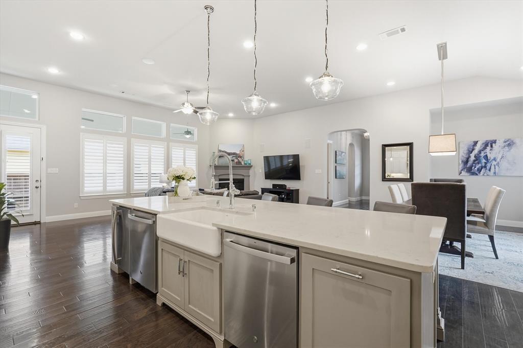 8713 Homestead Boulevard Rowlett, TX 75089 - Photo 6 of 28 a large kitchen with kitchen island a stove a sink a center island and wooden floor