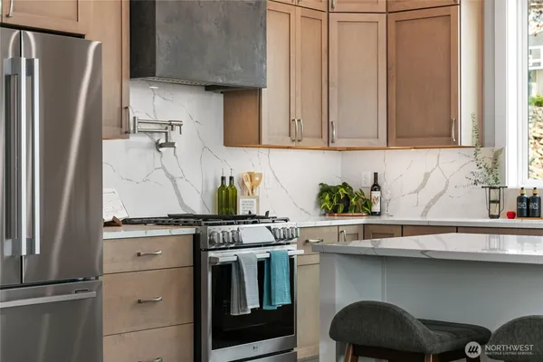 a kitchen with stainless steel appliances granite countertop a refrigerator and a sink