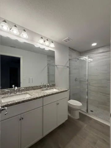 a bathroom with a double vanity sink toilet and shower