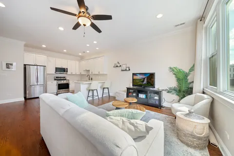 a living room with furniture kitchen view and a flat screen tv