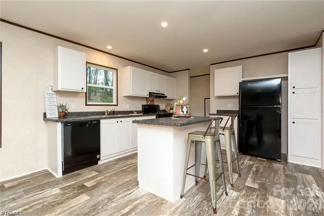 a kitchen with granite countertop a refrigerator stove top oven and sink