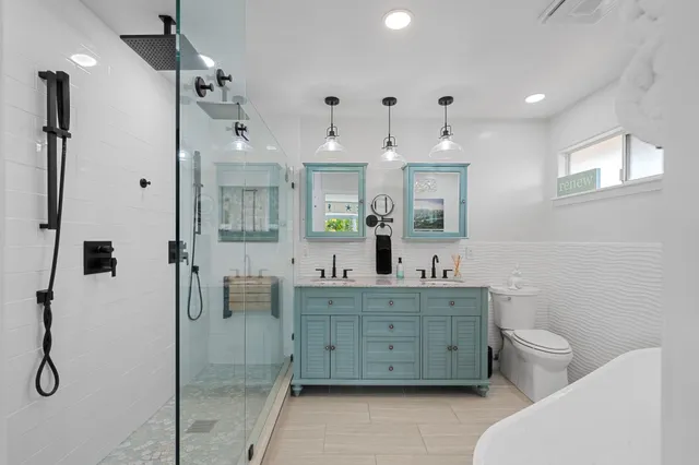 a bathroom with a double vanity sink mirror and toilet
