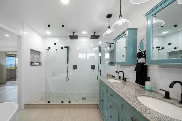 a bathroom with a granite countertop sink a large mirror and shower