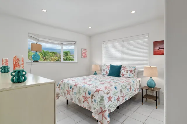 a bedroom with a bed table flowerpot and window