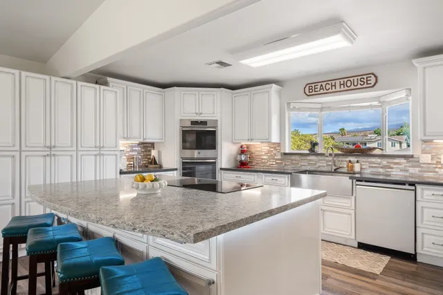 a kitchen with stainless steel appliances granite countertop a stove a sink and a microwave
