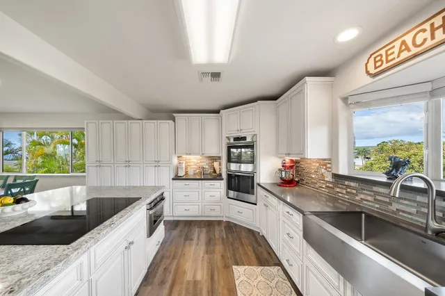 a kitchen with stainless steel appliances a sink window and cabinets
