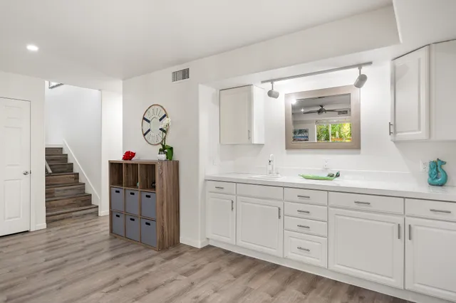 a very nice looking room with wooden floors and cabinets