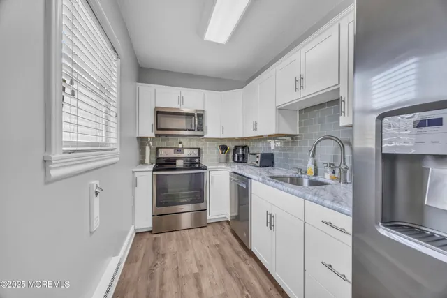 a kitchen with granite countertop a refrigerator stove and sink