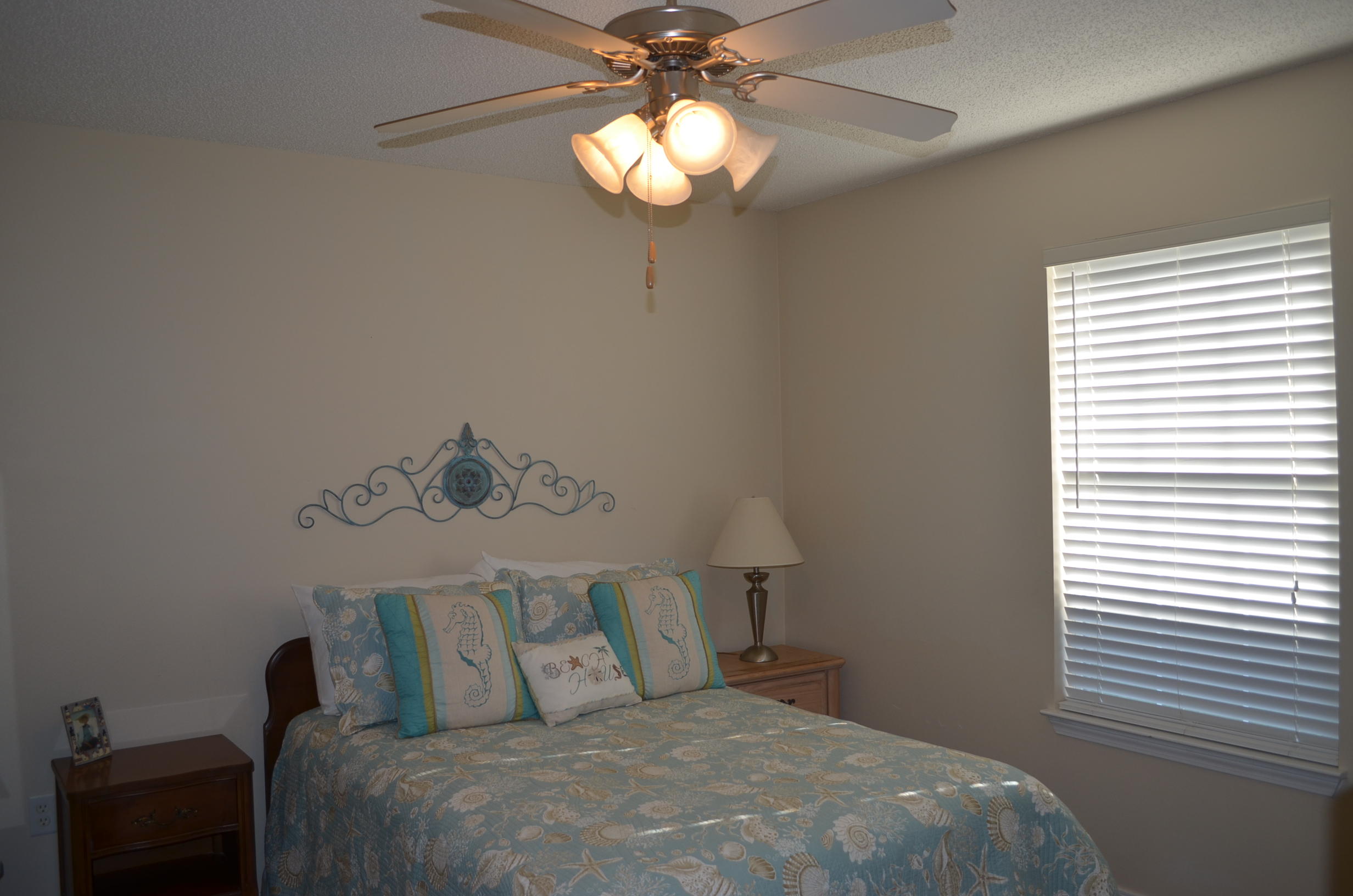 669 East Shipwreck Road Santa Rosa Beach, FL 32459 - Photo 20 of 35 a bedroom with a bed and a chandelier