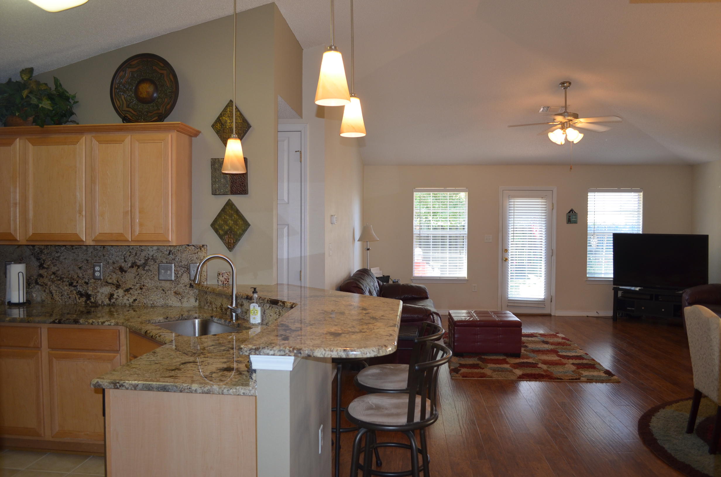 669 East Shipwreck Road Santa Rosa Beach, FL 32459 - Photo 5 of 35 a kitchen with a sink dishwasher a dining table and chairs with wooden floor
