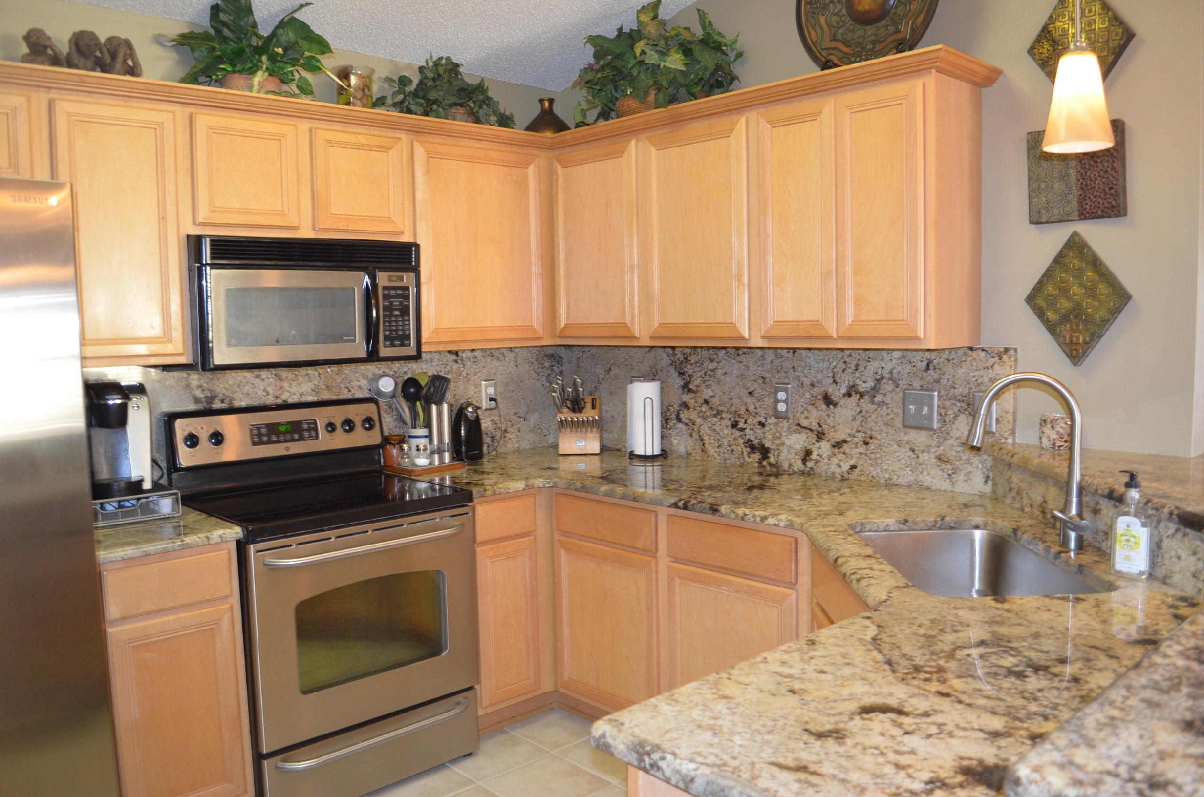 669 East Shipwreck Road Santa Rosa Beach, FL 32459 - Photo 7 of 35 a kitchen with granite countertop a stove a sink and a microwave