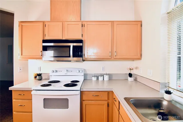 a kitchen with a sink a stove and cabinets