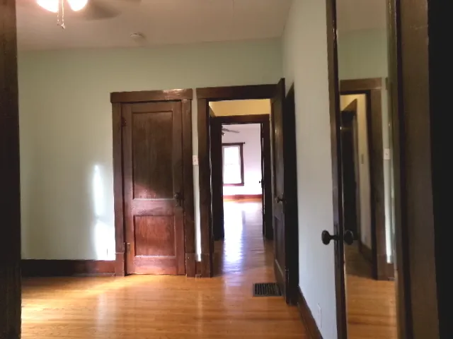 a view of a hallway with wooden floor