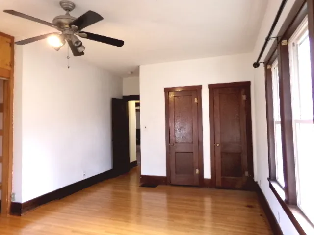 a view of a room with wooden floor and windows