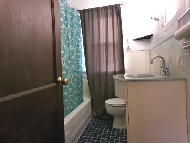 a bathroom with a granite countertop sink and a toilet