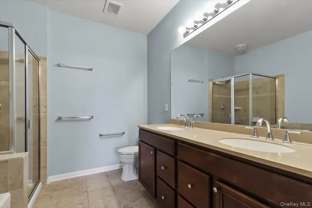a bathroom with a granite countertop sink a toilet and a mirror
