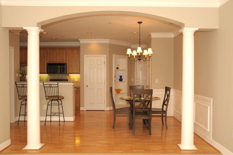 Welcome! The freshly painted interior of this tastefully appointed condominium features classic columns, crown molding, built-in shelving nook, wainscot panels, and high ceilings.  Hardwood flooring runs from entry through kitchen and dining area.