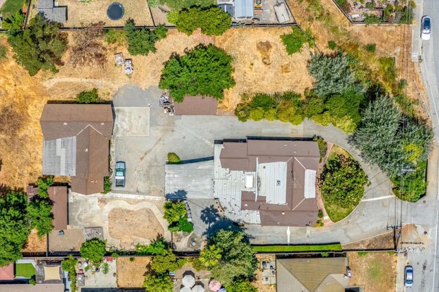 an aerial view of a house with a yard and a large tree