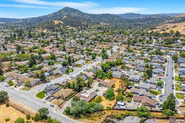 an aerial view of residential houses with outdoor space and trees
