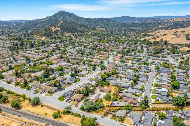 an aerial view of residential houses with outdoor space and trees
